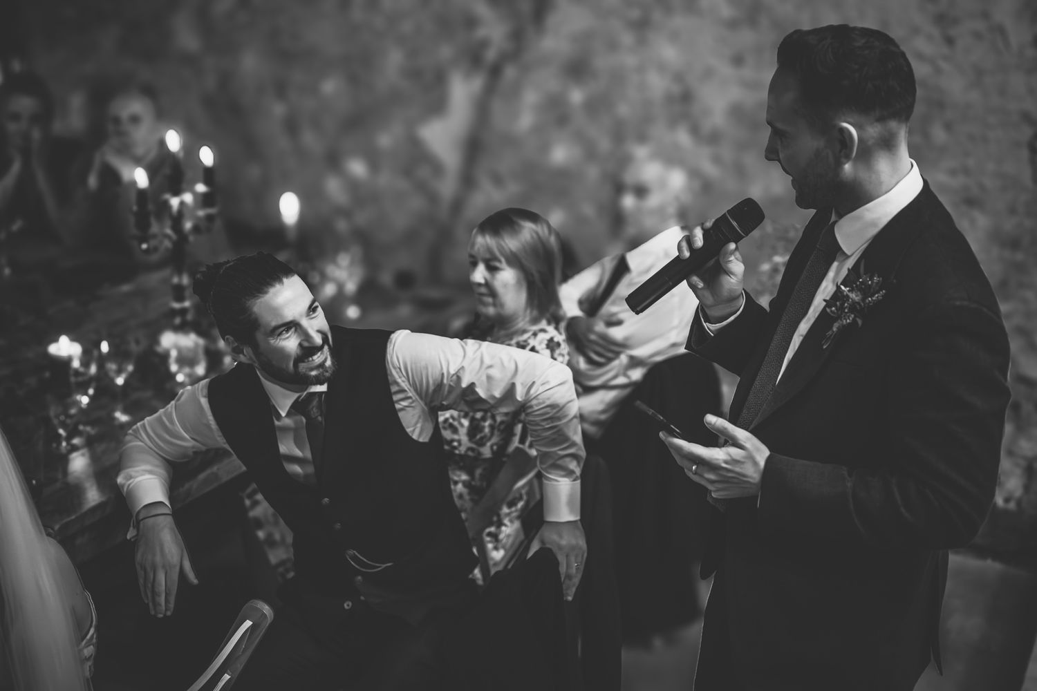 Dark and moody reception scene with guests celebrating and dancing at an evening wedding party.