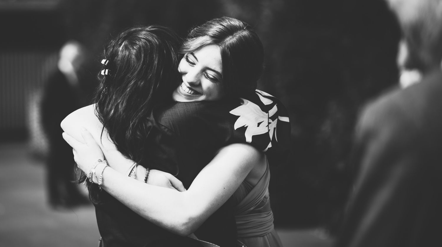 A couple embraces in an emotional moment during what appears to be a wedding celebration.