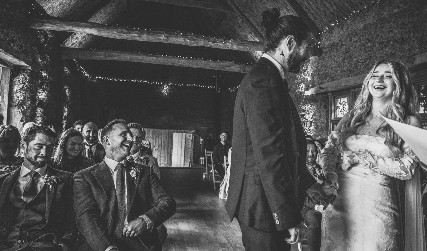 Black and white wedding photos arranged in a filmstrip-style collage showing reception celebration moments.