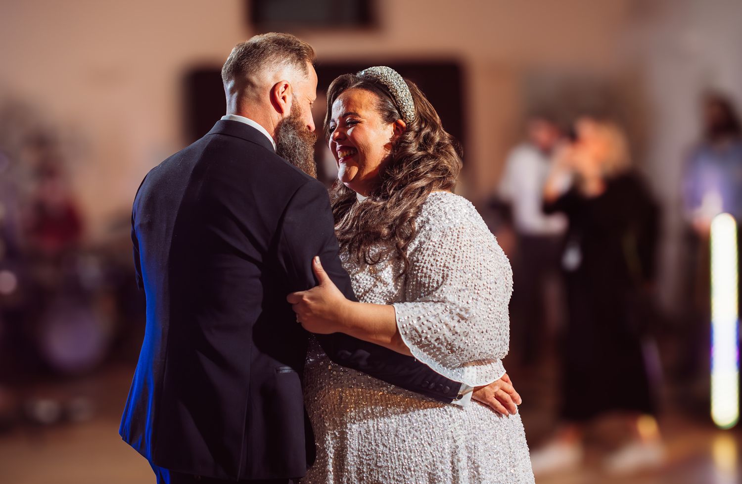 A couple shares an intimate dance together during what appears to be a wedding reception celebration.
