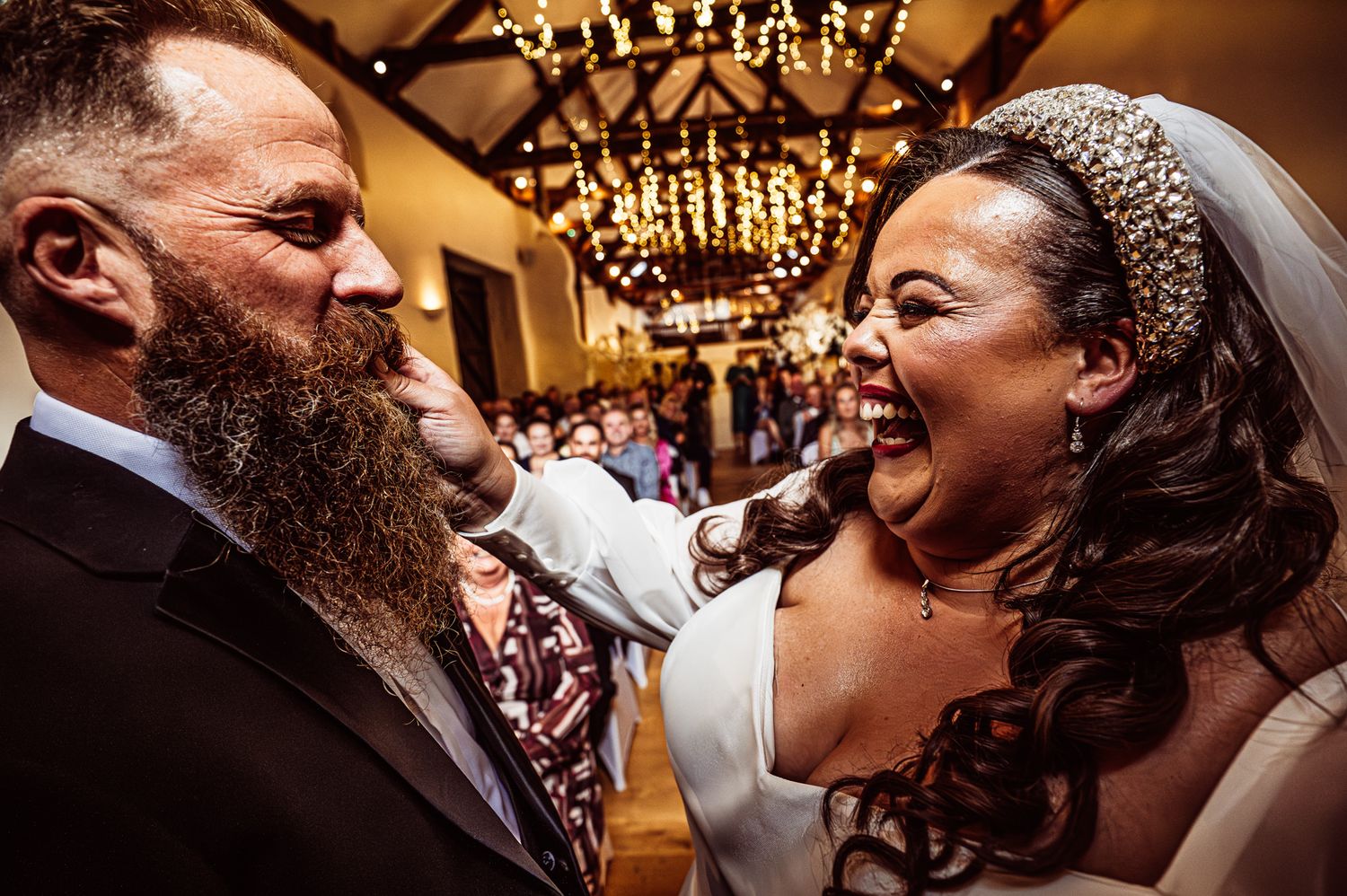 Couples dancing under ornate chandeliers at an elegant indoor celebration.