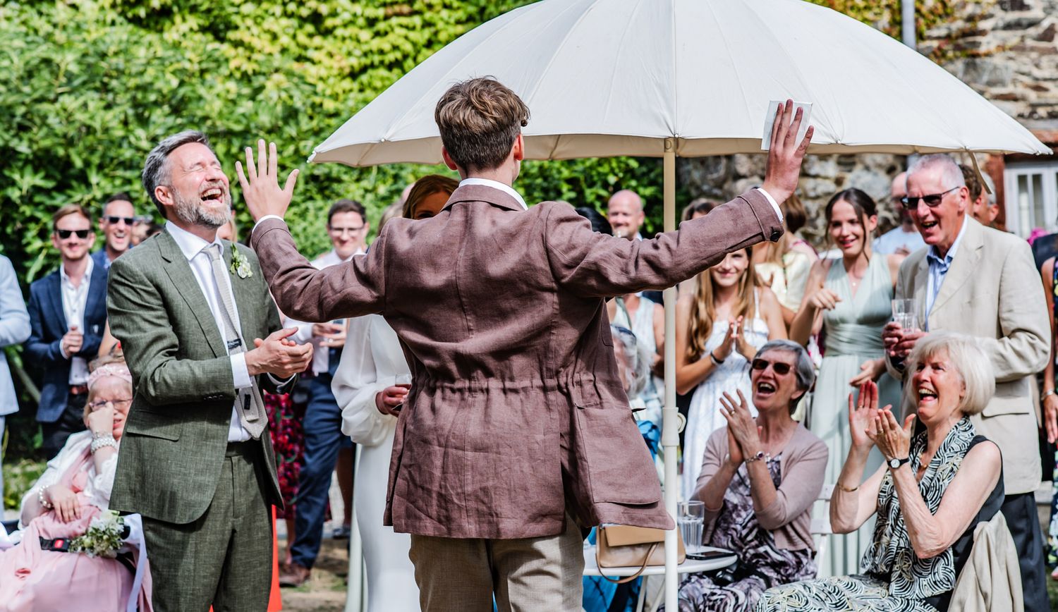 Wedding guests dance and celebrate on an outdoor patio during a lively reception party.
