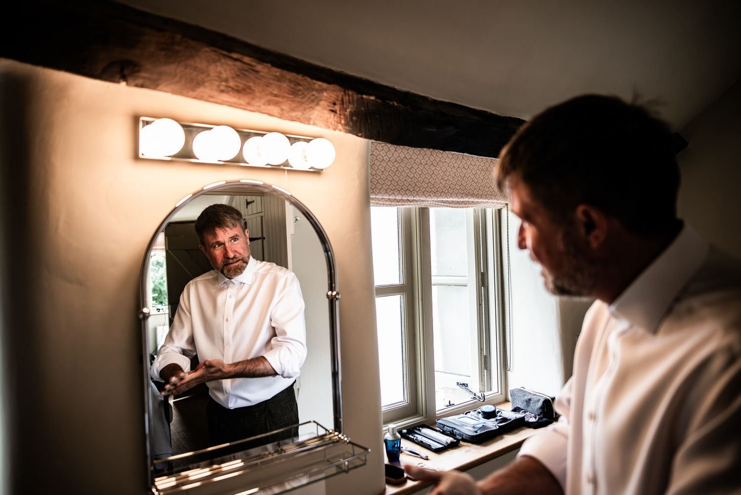 Professional chef in white uniform working in a commercial kitchen setting with modern equipment and stainless steel surfaces.
