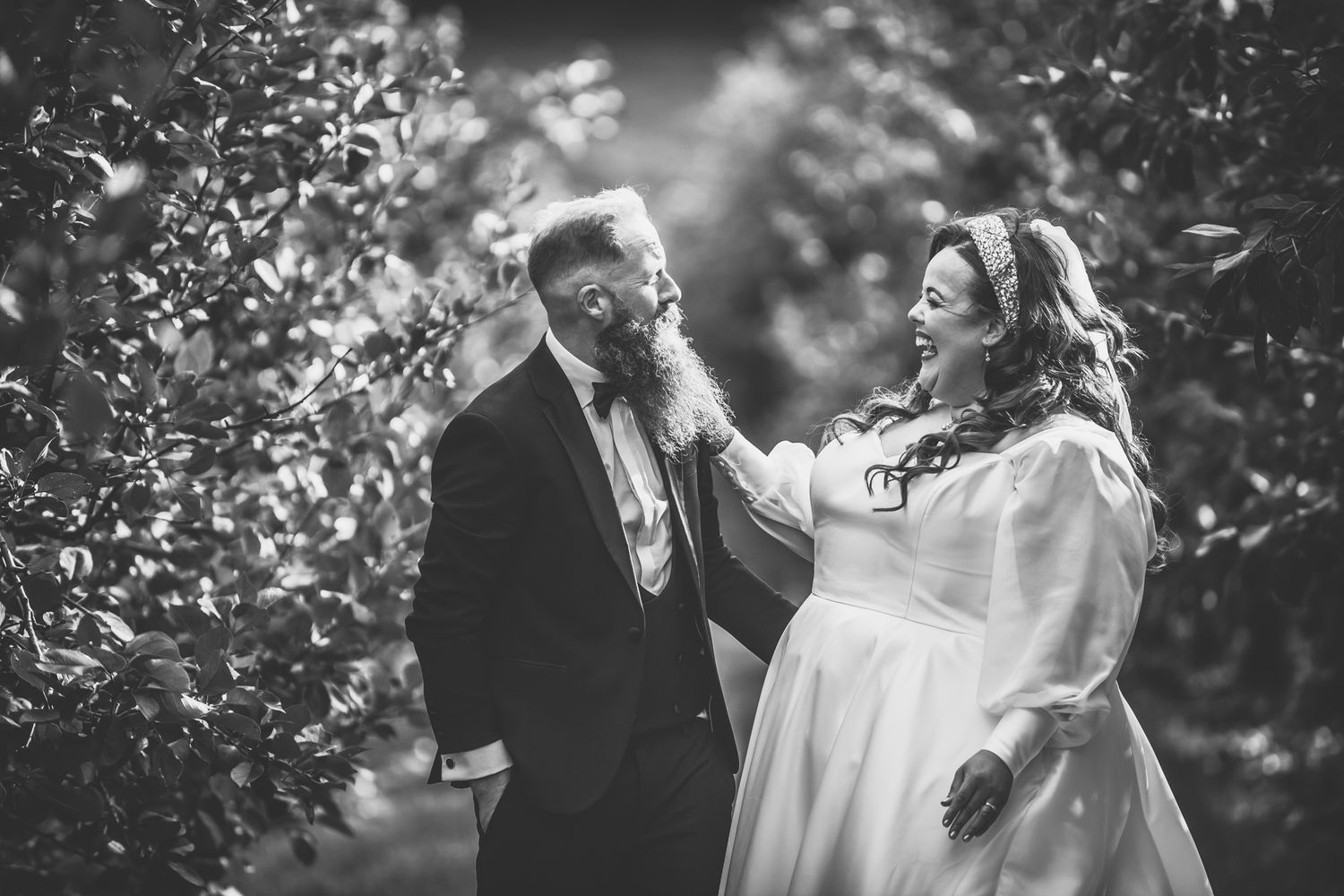 A romantic black and white photo series of a couple sharing intimate moments during their outdoor wedding celebration.