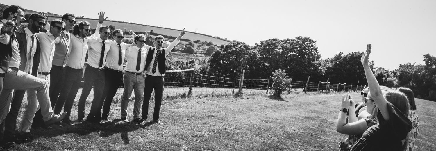 Black and white panoramic view of guests gathered outdoors at a social event.