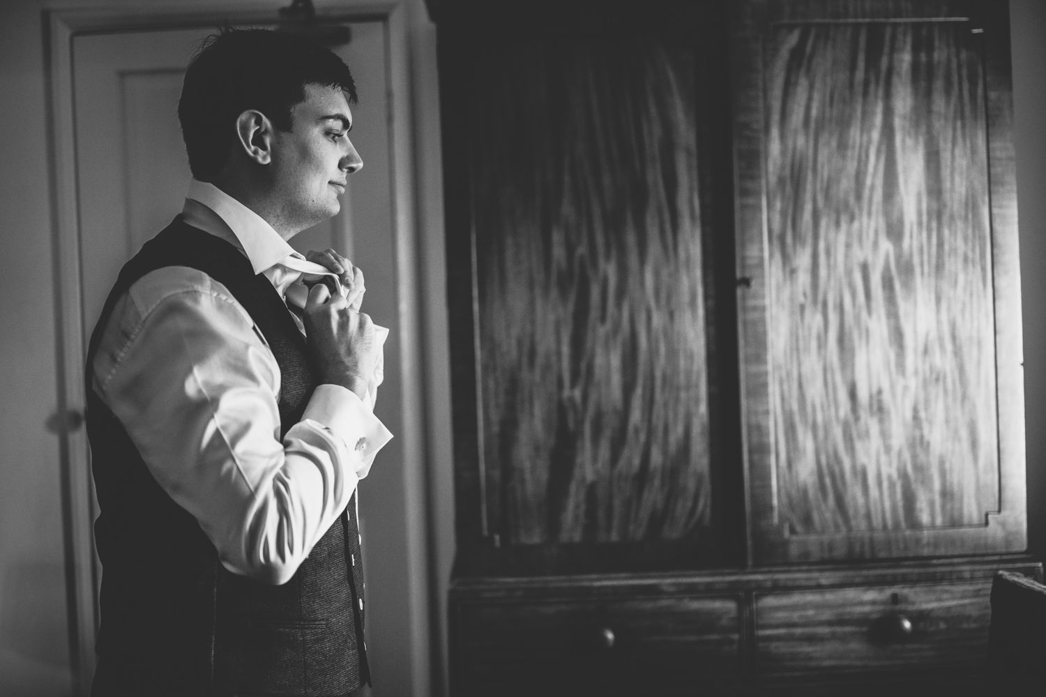 A series of black and white photographs showing someone smoking a cigarette in dramatic lighting.