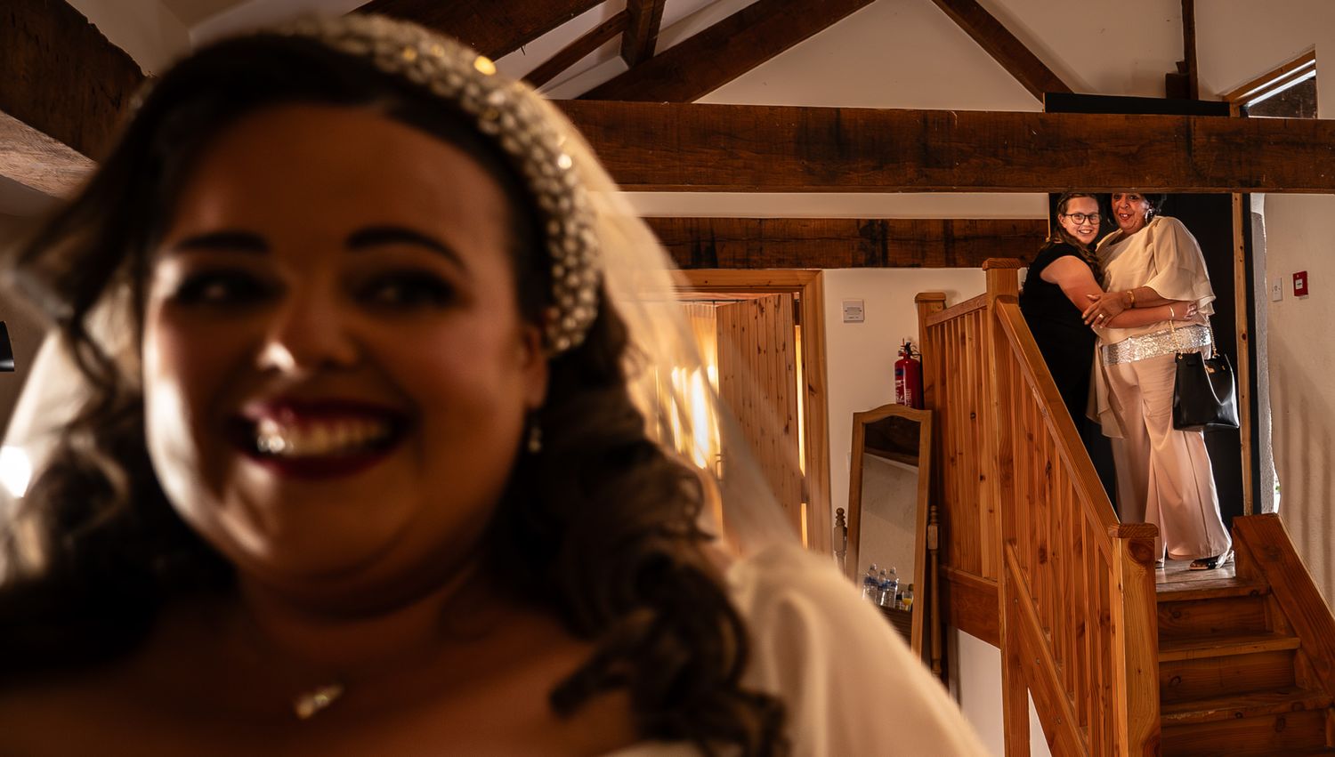 A couple shares a romantic moment during their wedding celebration in a rustic wooden venue.
