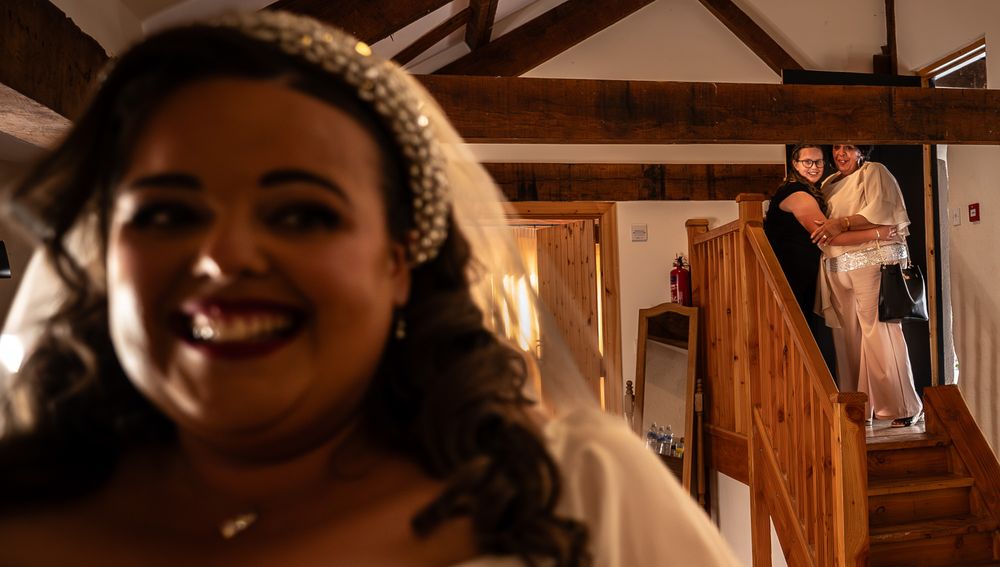 A couple shares a romantic moment during their wedding celebration in a rustic wooden venue.