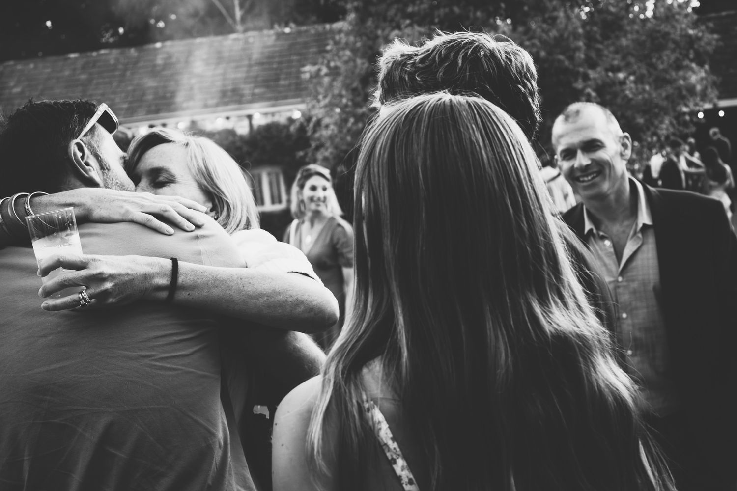 Black and white wedding photos showing candid moments of celebration and dancing at an outdoor reception.