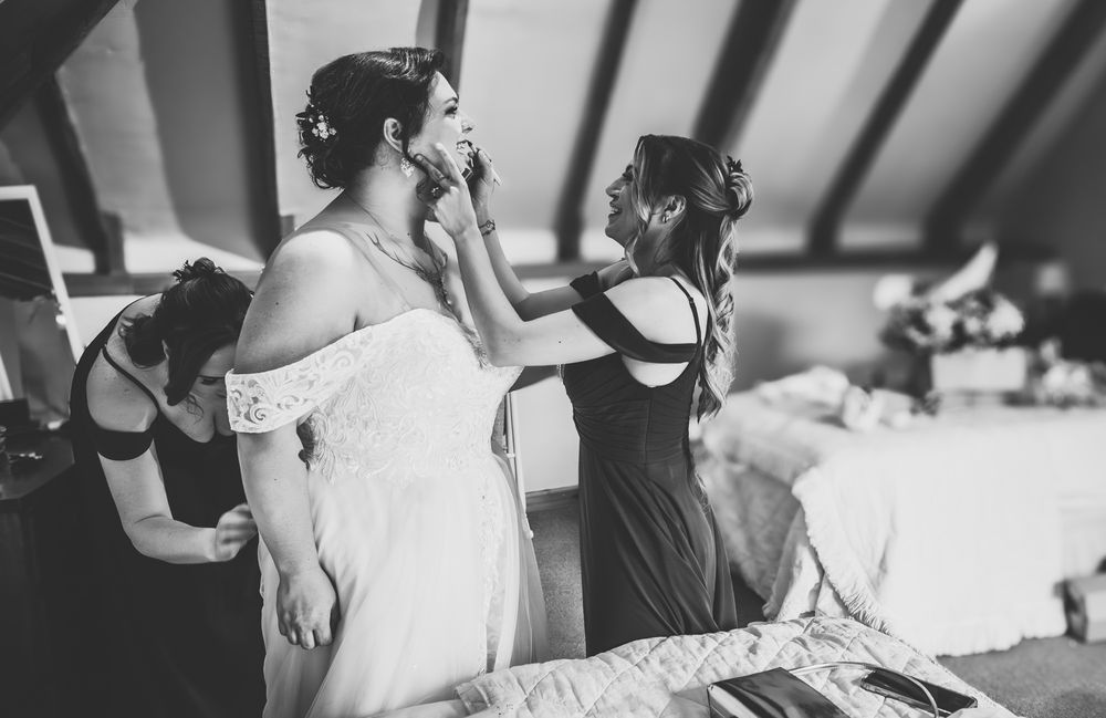 A black and white photo series showing candid moments from a wedding celebration with dancing and festivities.
