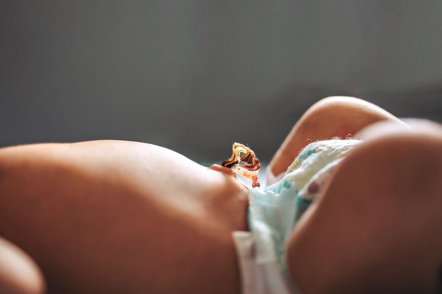 Close-up macro shot of a tiny wedding ring resting on skin in soft lighting.