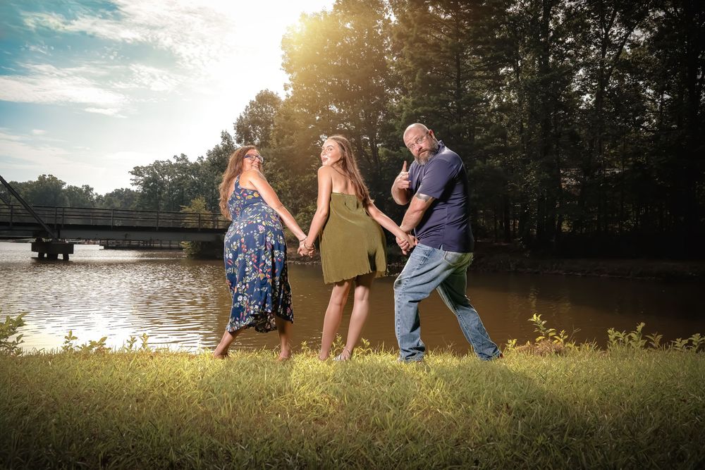 A group enjoys a peaceful summer evening by a serene lake as golden sunlight filters through the trees.