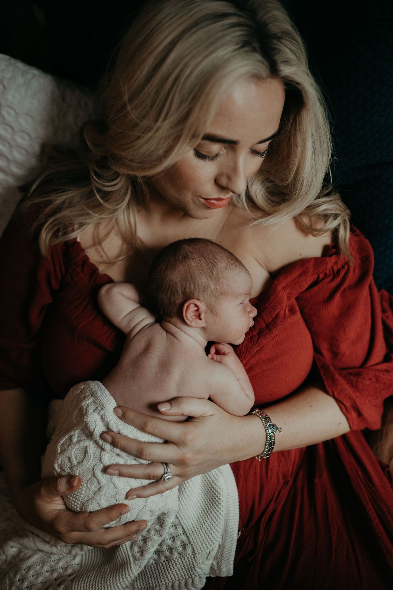 a mother resting in the bed with her new born baby on her chest