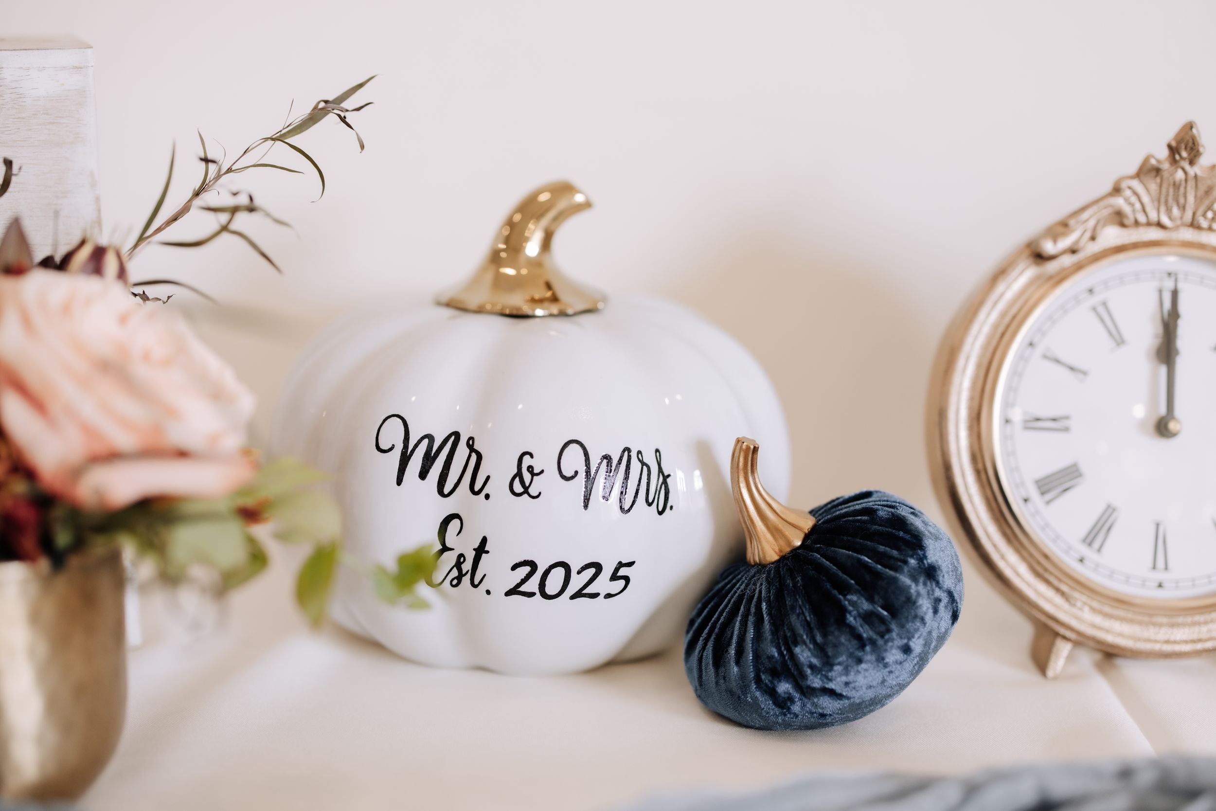 Vintage clocks and wedding decor elements arranged in a minimalist style on a white surface.