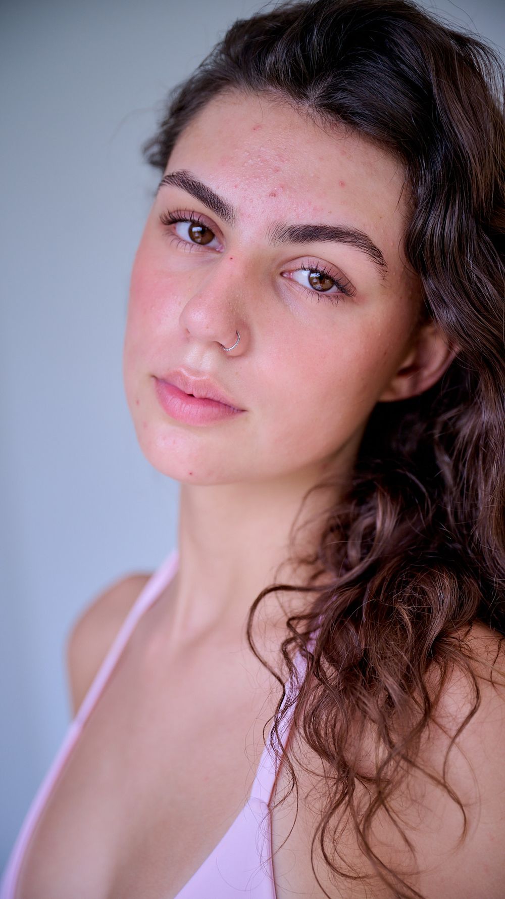 Portrait series showing different angles and expressions with curly brown hair and pink lipstick against a light background.