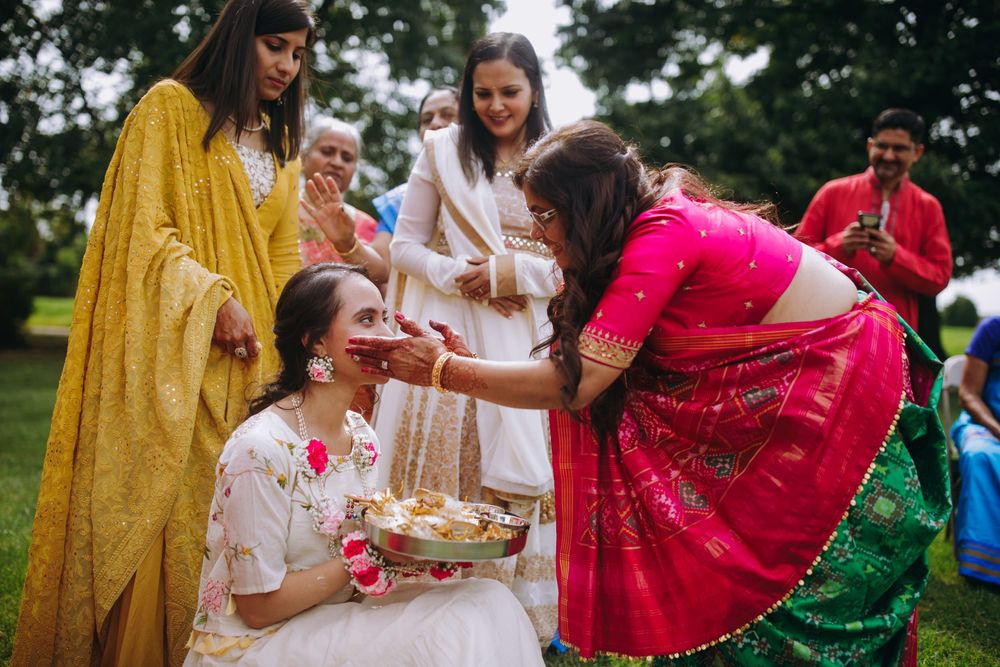 A festive outdoor celebration with guests wearing vibrant traditional attire in red, yellow and green colors.