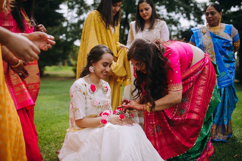 Outdoor celebration with guests in vibrant traditional Indian attire throwing flower petals.