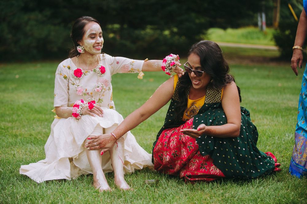 A joyful outdoor celebration with colorful flowers and traditional Indian attire in a garden setting.