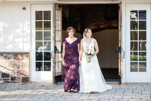 Wedding party poses in doorways of elegant white building with classic architecture.