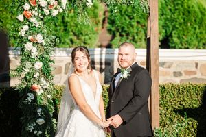 Outdoor wedding ceremony space decorated with lush floral arrangements and greenery.