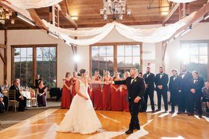 Wedding celebration in an elegant venue with draped fabric decor and chandelier lighting.