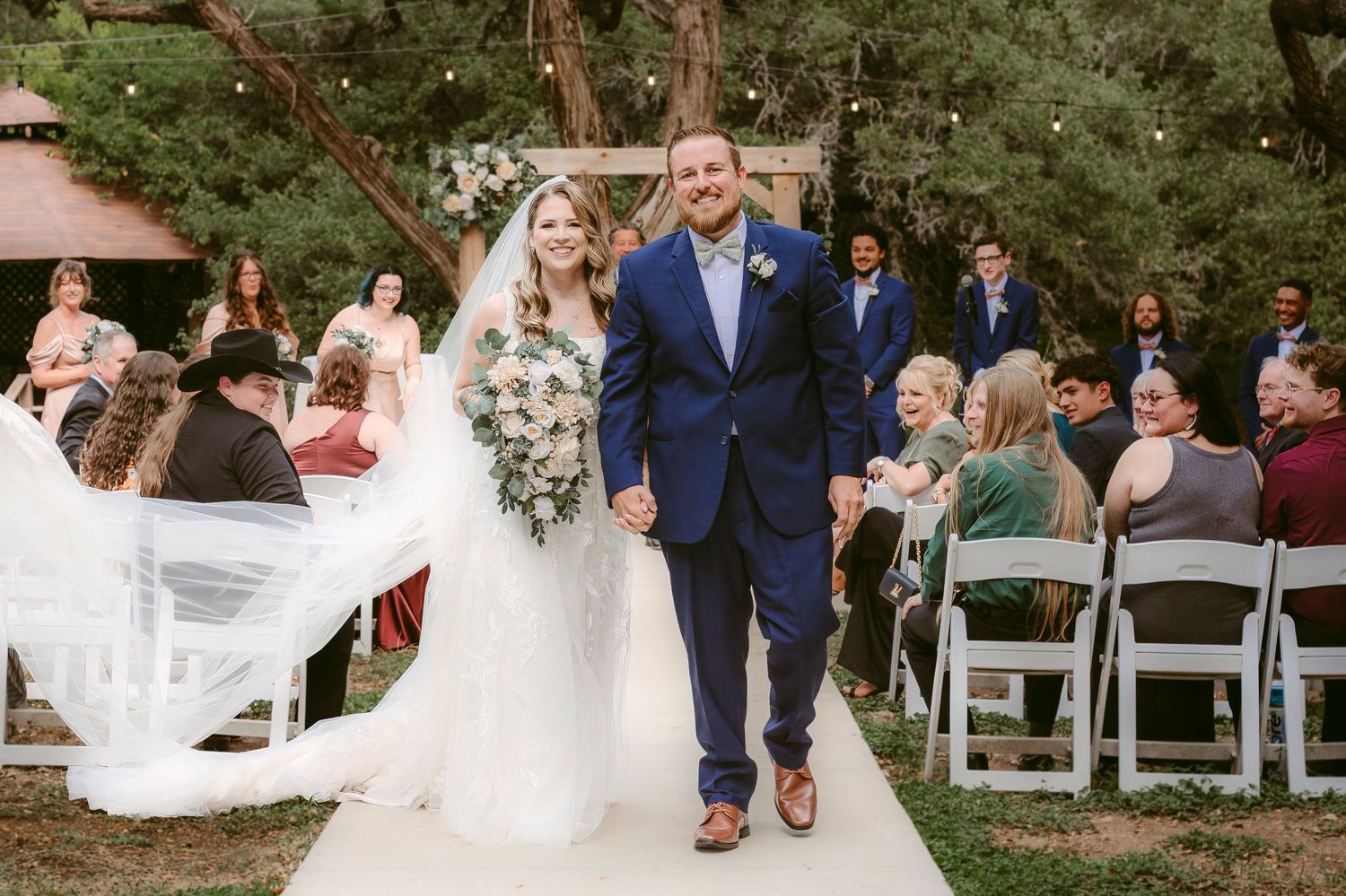 A wedding couple and guests celebrate with joyful dancing at an outdoor garden reception in San Antonio, Texas