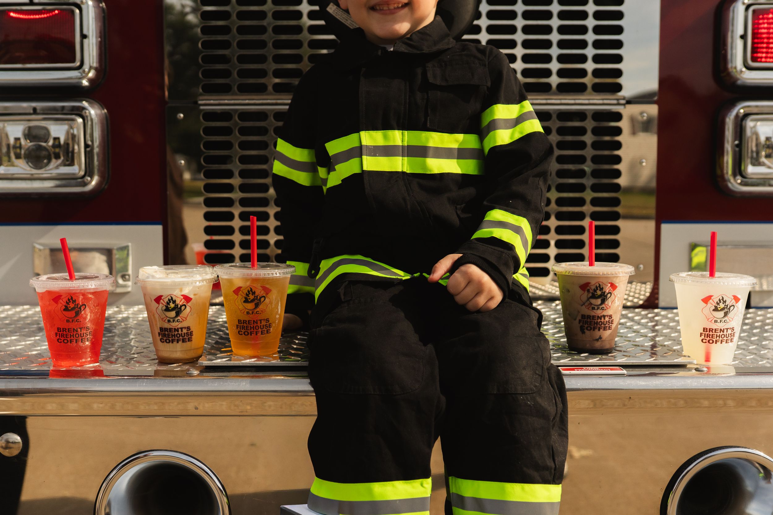 Figure in firefighter costume with reflective gear near emergency vehicle.