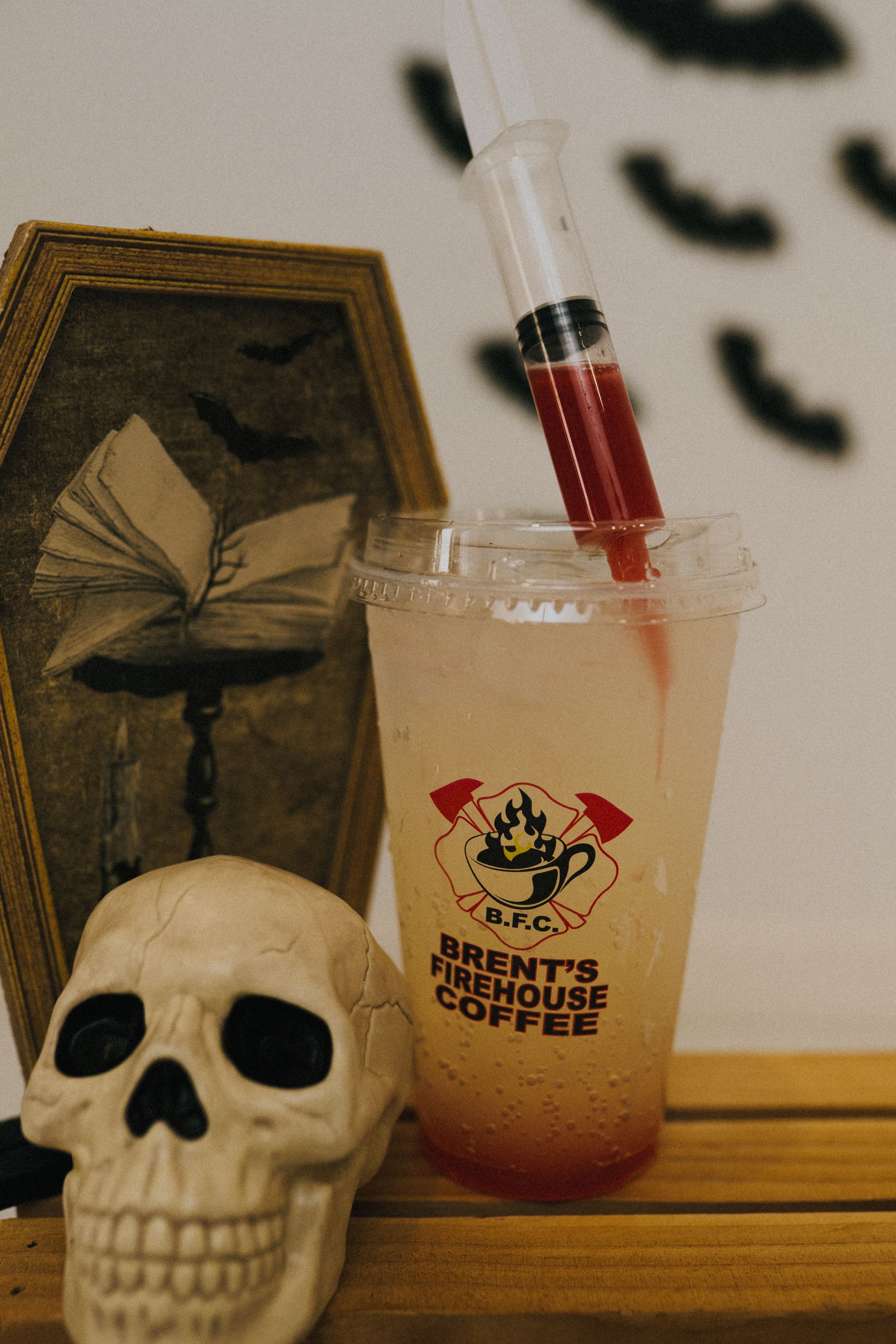 Decorative skull display next to branded coffee cups in atmospheric lighting.