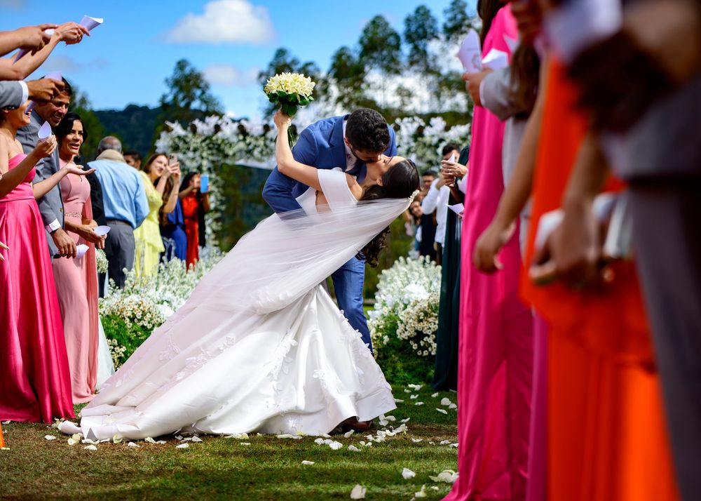 A colorful photograph of a bride and groom kissing while the groom gently dips the bride