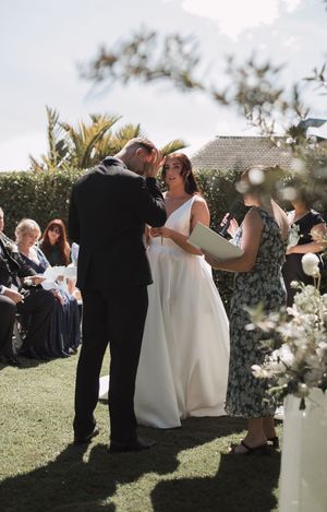 Wedding guests mingle and celebrate on a sunny lawn during an outdoor reception.