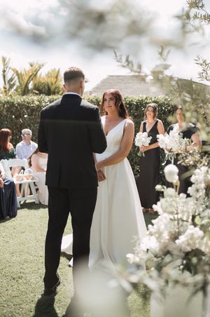 Spring wedding ceremony on a green lawn with white cherry blossoms in the foreground.