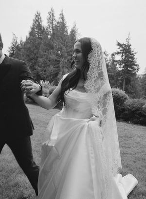 Black and white photo of a bride's flowing white dress during an outdoor wedding dance.