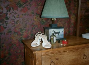 A series of seven dark, moody photographs showing details of a bedroom interior with floral wallpaper and wooden furniture.