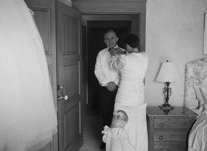 Black and white wedding photography sequence showing movement and preparations in a room.