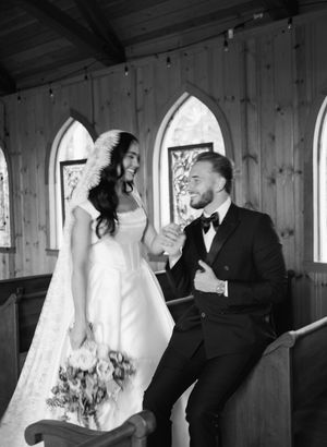 Black and white photos of a couple sharing intimate moments in a rustic wooden chapel with arched windows.