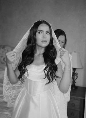 Black and white photo series showing a person in a white lace dress with long dark hair posing against a wall.