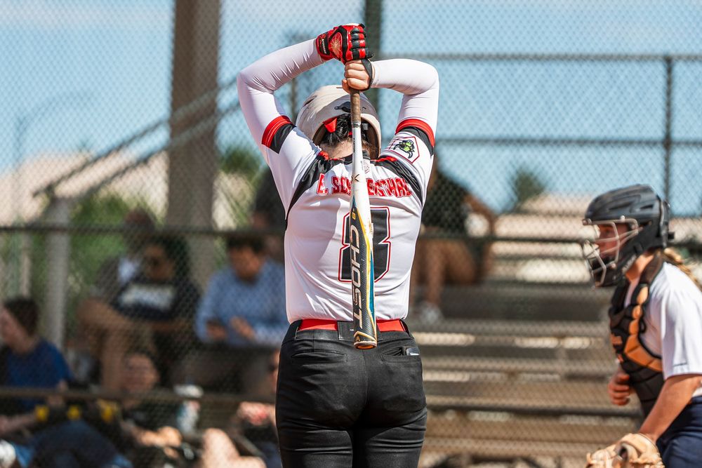 Girls softball player stretching before their turn at bat