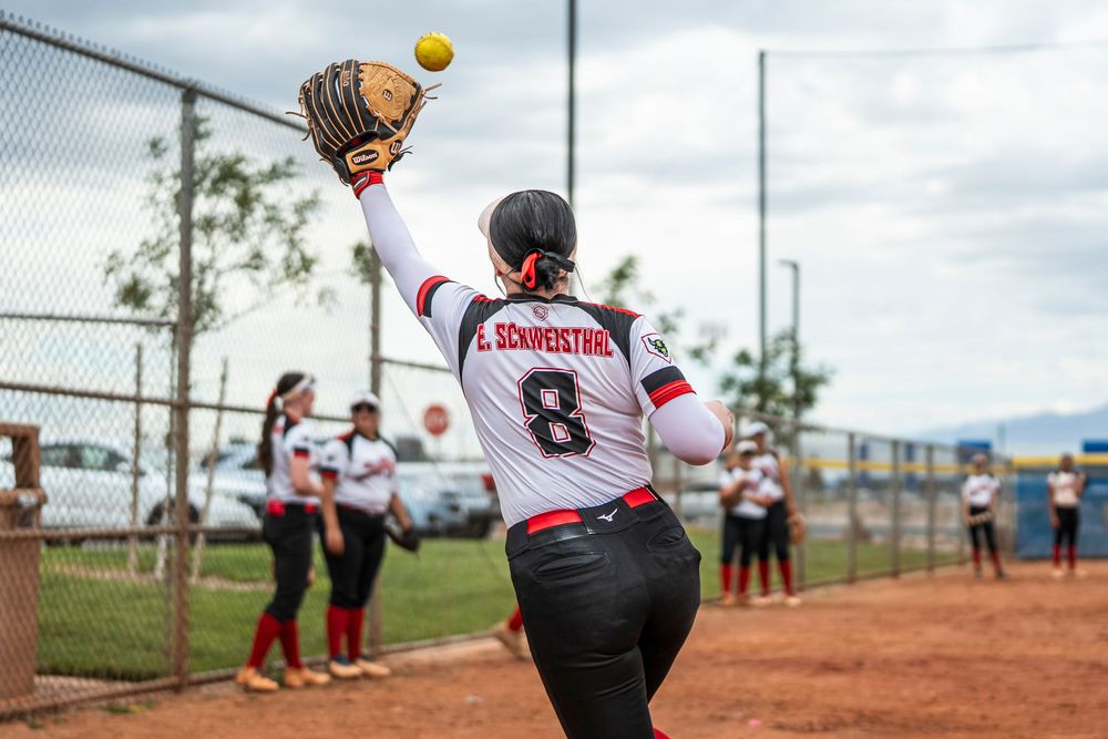 Girls softball player warming up by catching a ball