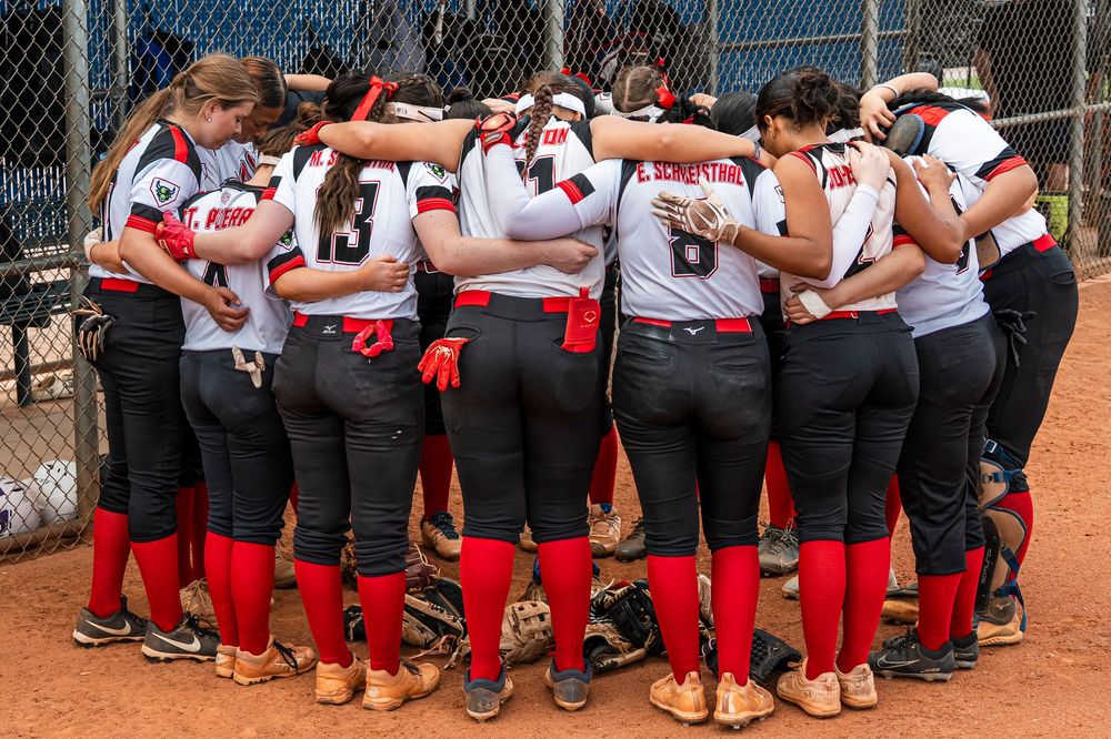Girls softball team huddling together