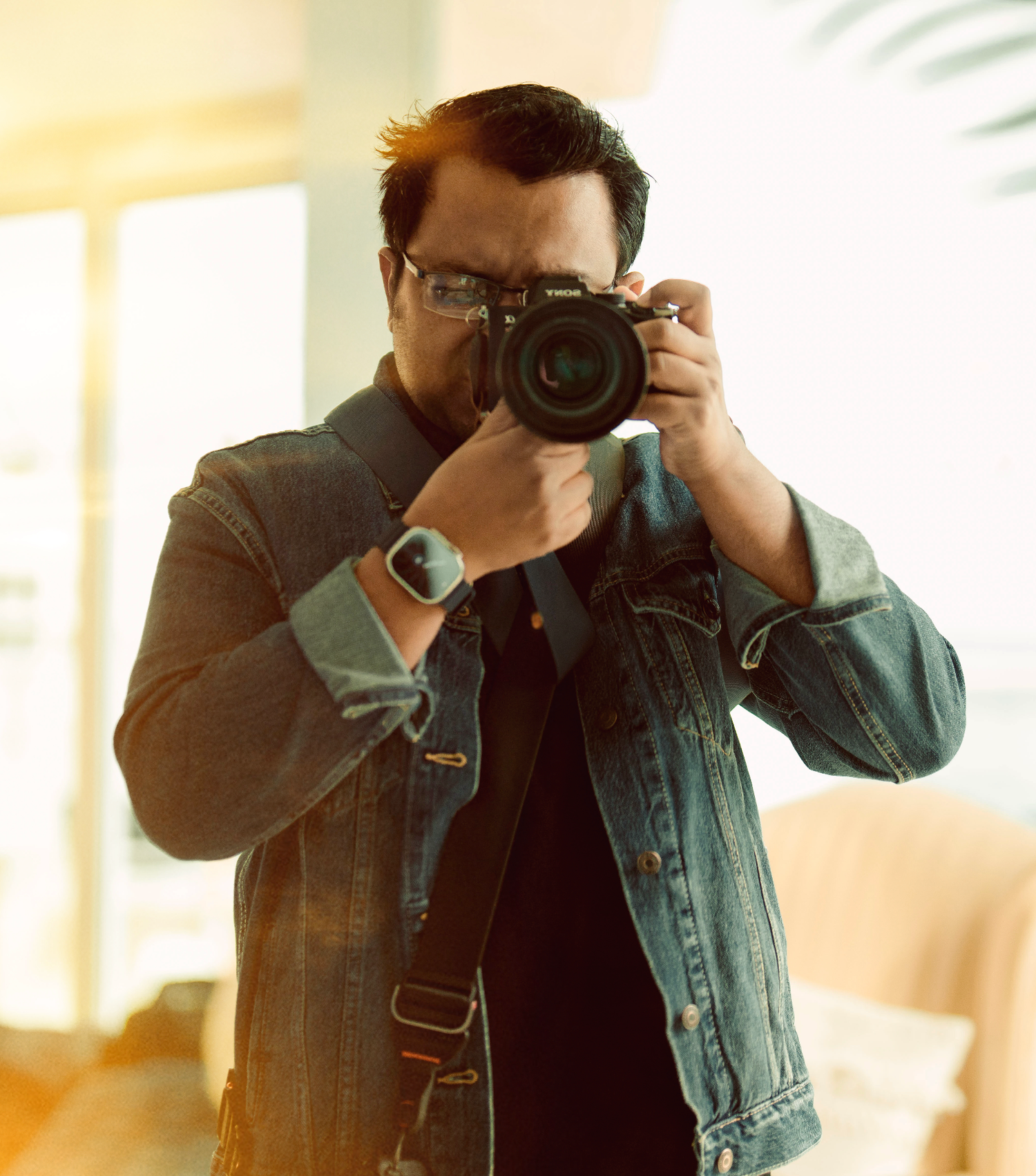Photographer with red beanie and black jacket captures scenic mountain landscapes with professional camera equipment.