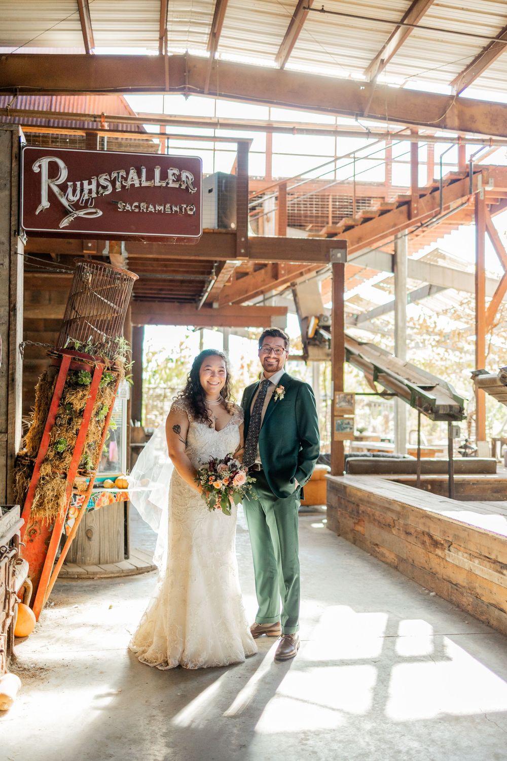 Wedding couple poses in rustic industrial venue with natural lighting and exposed brick walls at Ruhstaller venue.