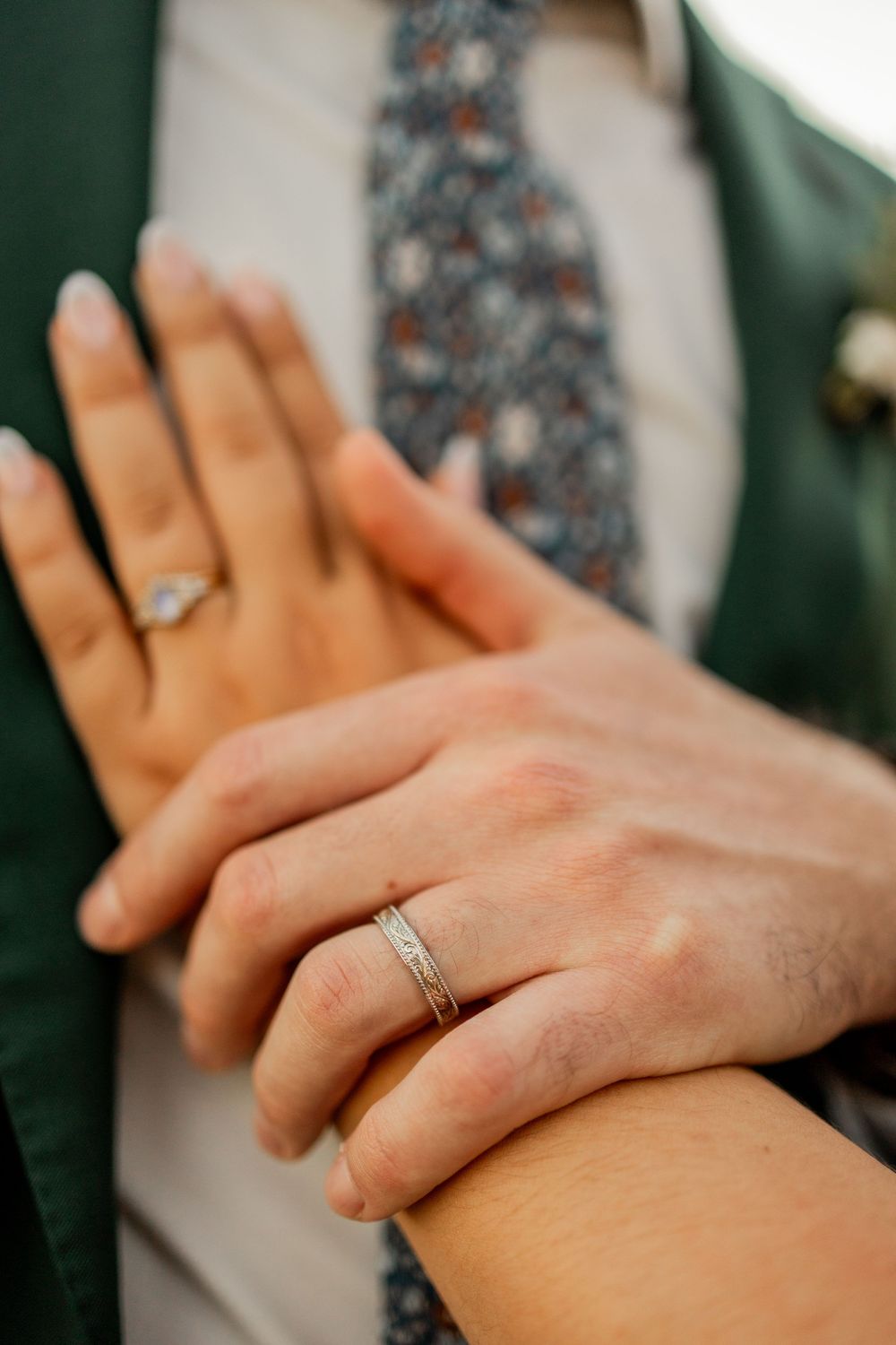 Close-up series showing hands with engagement ring interlocking fingers in romantic poses against floral background.