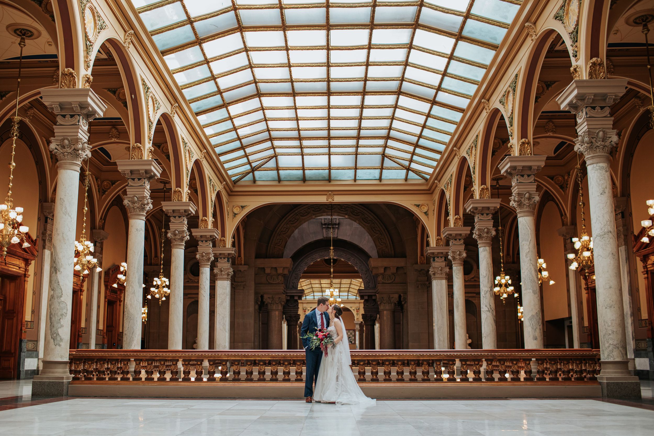 Stunning architectural panorama of a historic venue with glass ceiling and elegant columns.