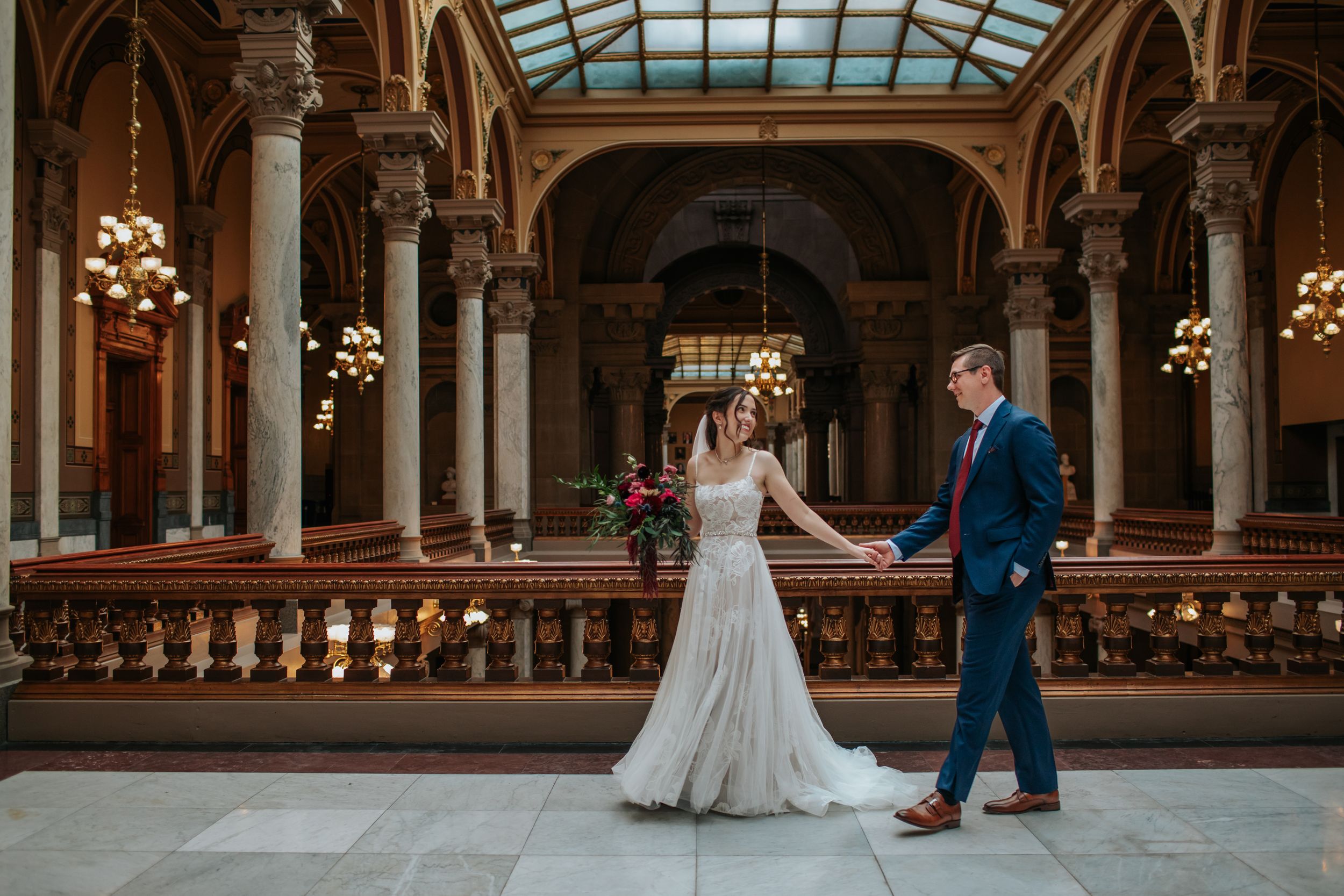Wide view of a majestic wedding venue featuring classical architecture and natural skylight.