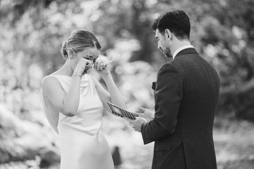 Black and white photo of a couple sharing an emotional moment while exchanging vows. Weatherlow Farm wedding. Westport Massachusetts