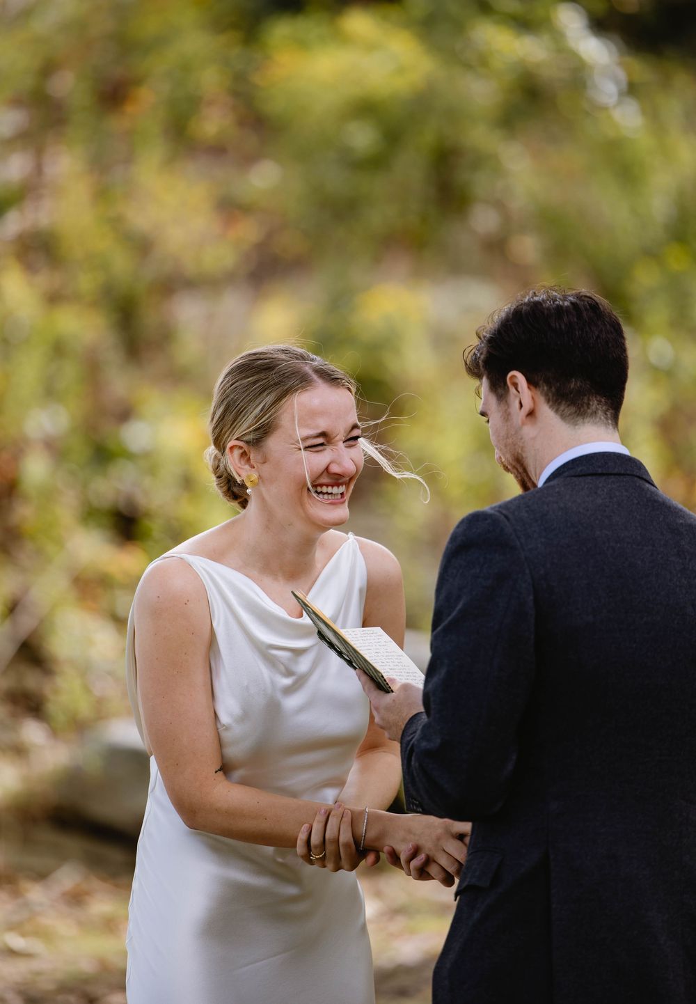 A couple in wedding attire exchanges letters in a sun-dappled forest setting. Weatherlow Farm wedding. Westport Massachusetts.