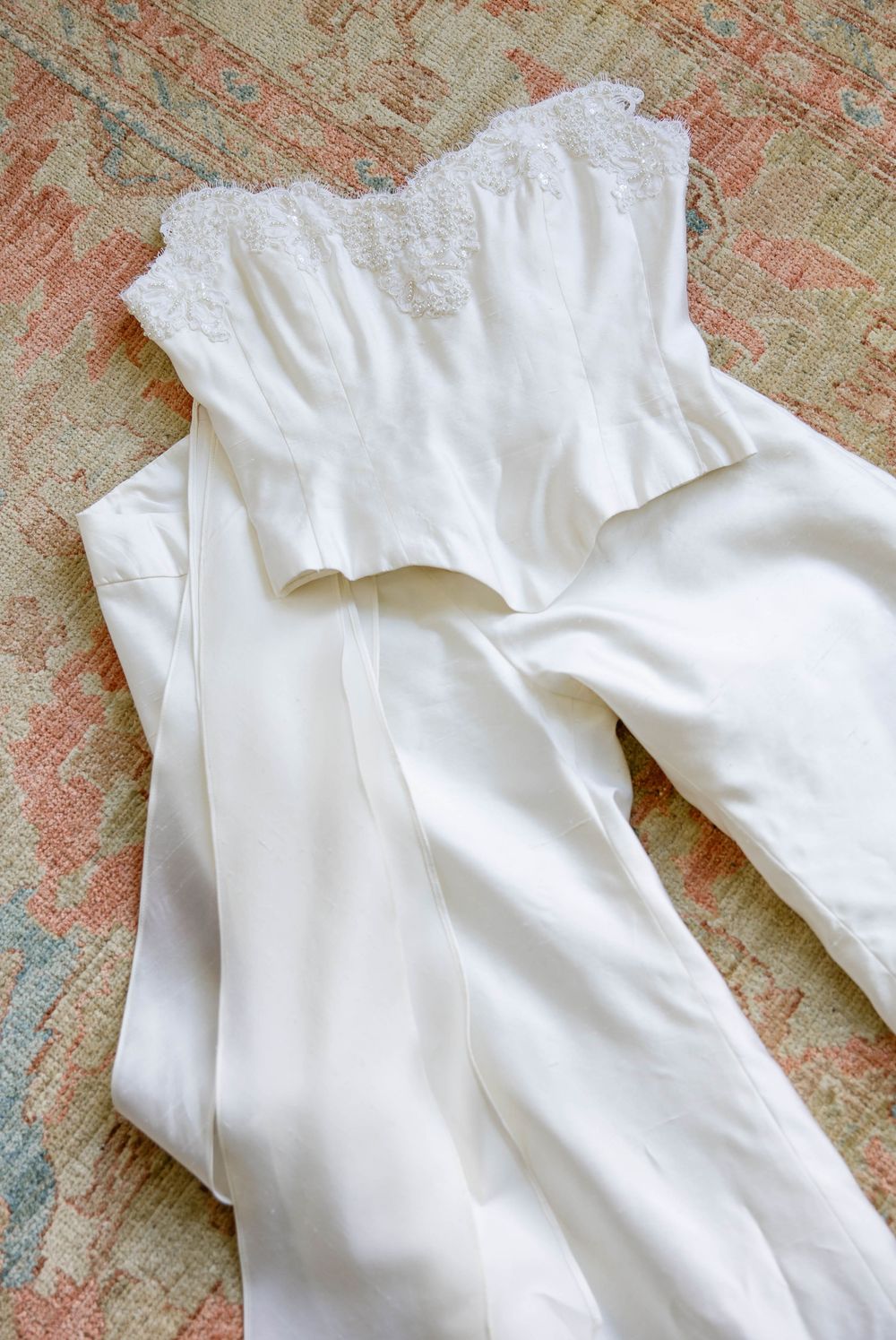 White wedding dress detail showing delicate ruffled neckline on textured background. Weatherlow Farm wedding. Westport Massachusetts.