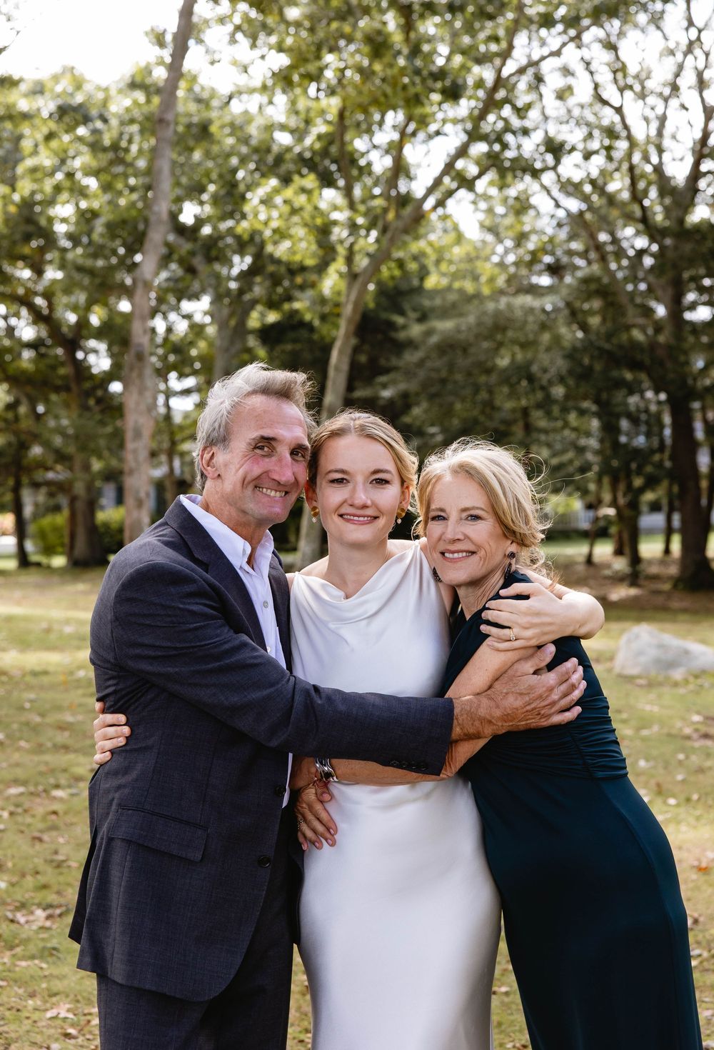 A couple embraces during wedding celebrations in an outdoor garden setting. Weatherlow Farm wedding. Westport Massachusetts.