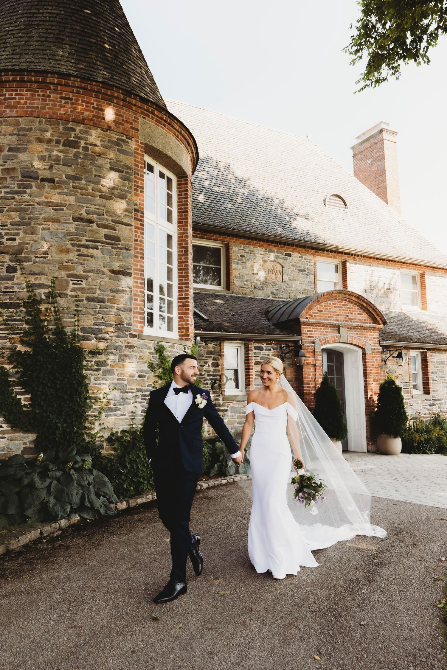 Elegant wedding portraits outside historic stone building with rustic architectural details.