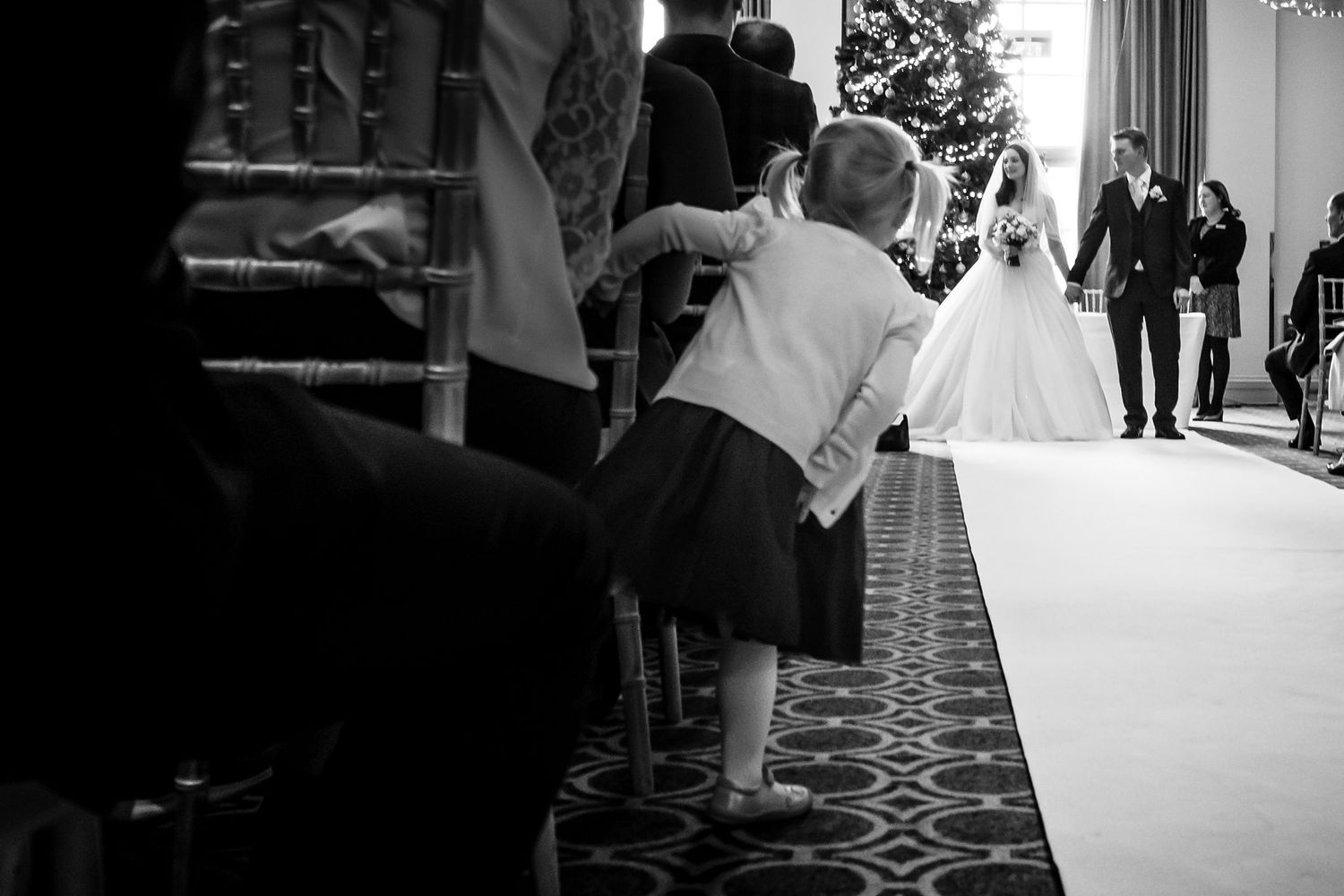 A series of black and white wedding photos showing couple and celebrating at an elegant reception.